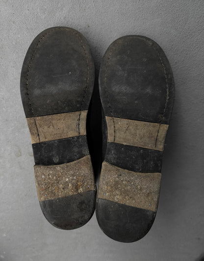 Pair of worn-in leather shoes on a gray concrete floor