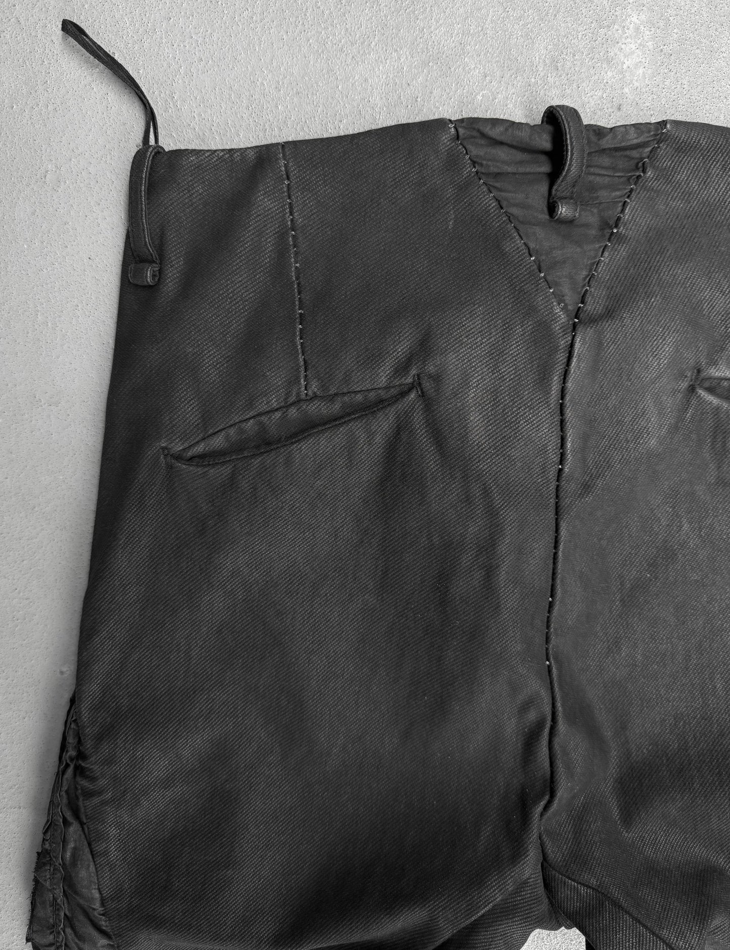 Close-up of a black jacket with a textured surface on a light gray background