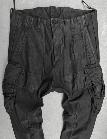 Black cargo pants hanging against a light gray background