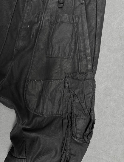 Close-up of black pants with multiple pockets on a gray background