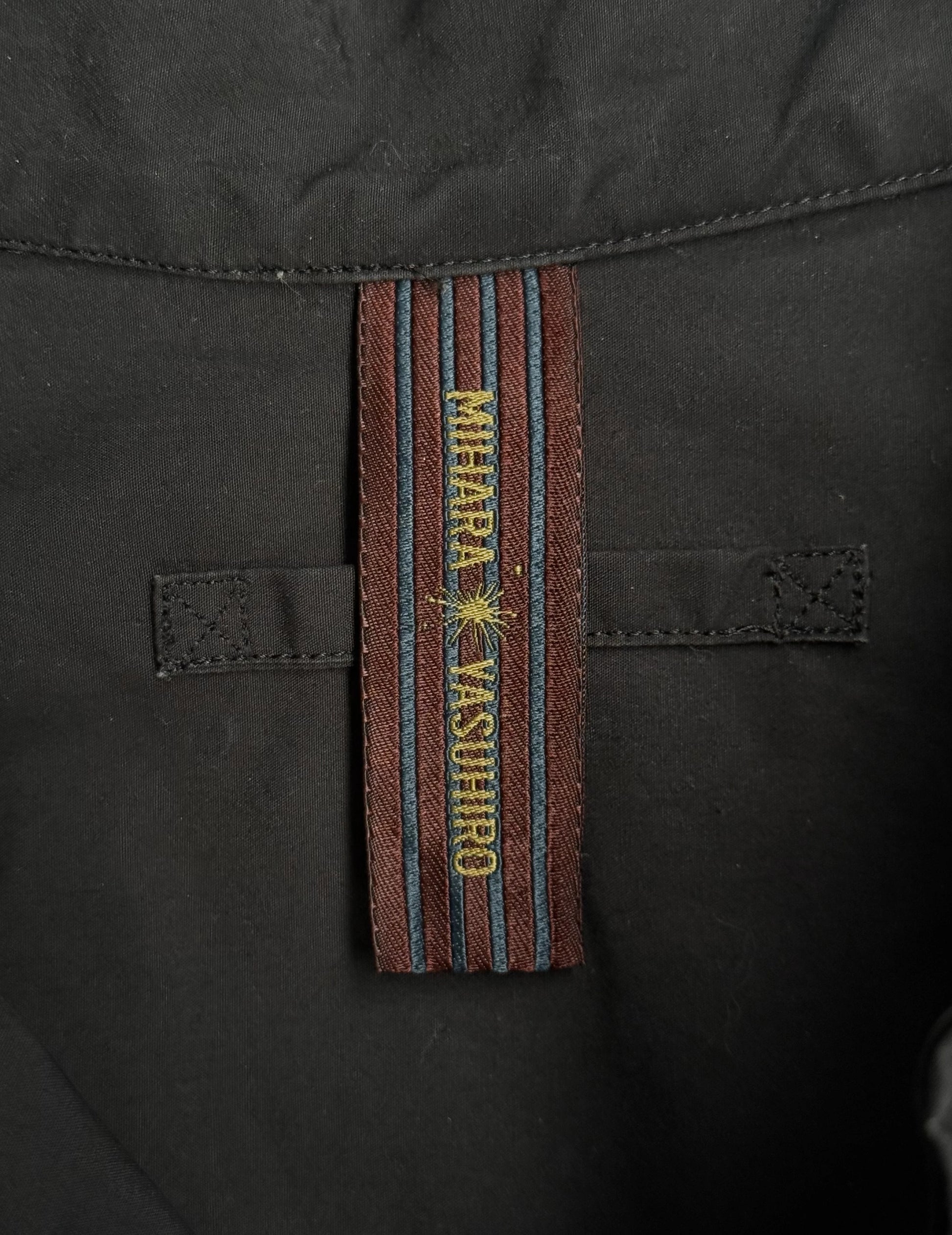 Close-up of a black jacket with a branded strap displaying 'Mihara Yasuhiro'.