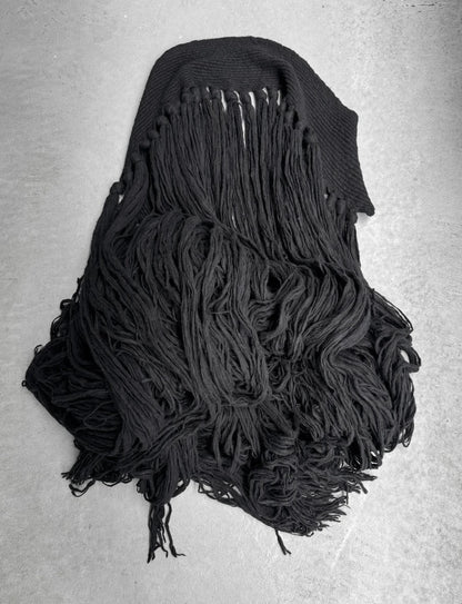Black knitted scarf with fringe on a gray background