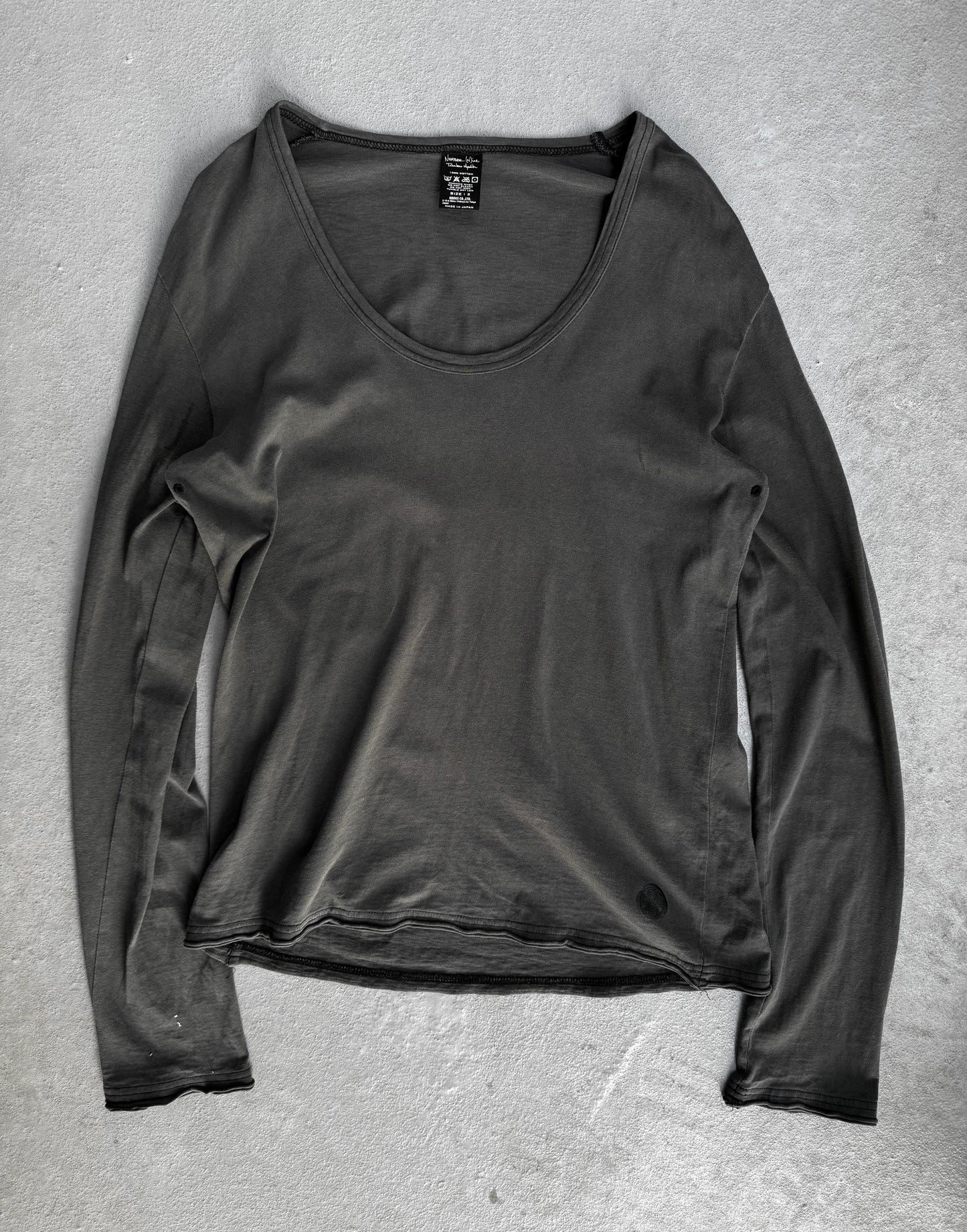 Dark gray long-sleeve shirt on a textured gray surface