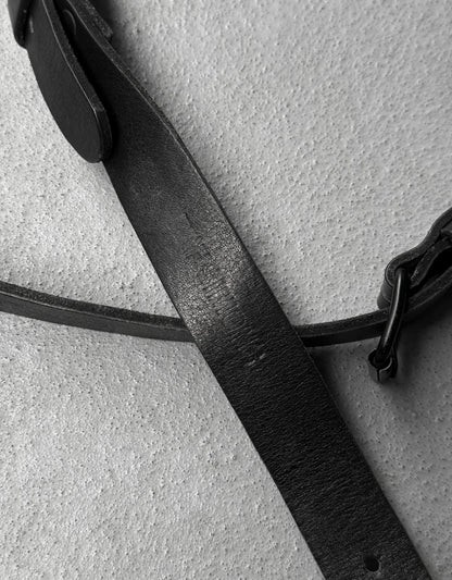Close-up of a black leather strap on a textured gray surface