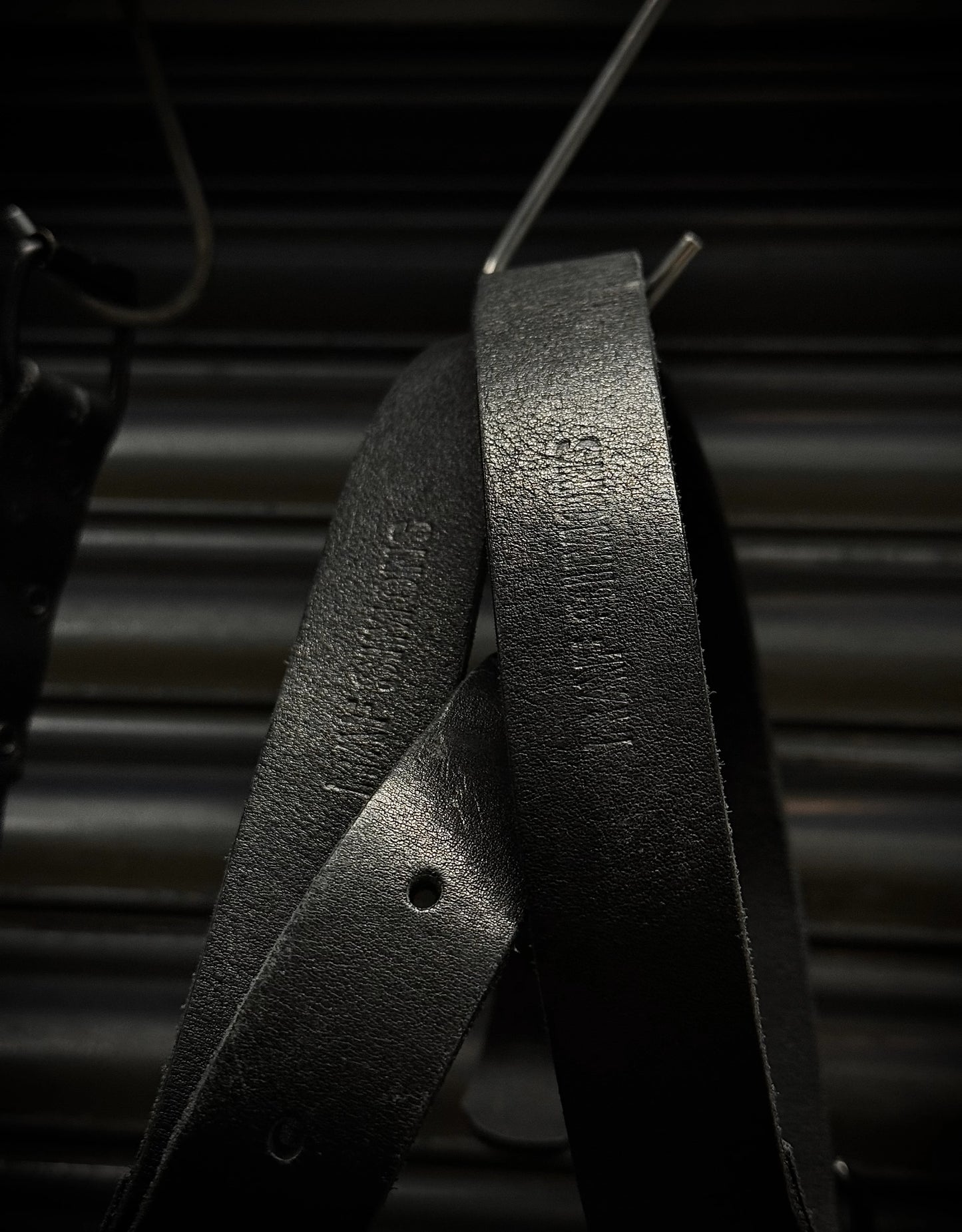 Close-up of a black metal object with text on a dark background