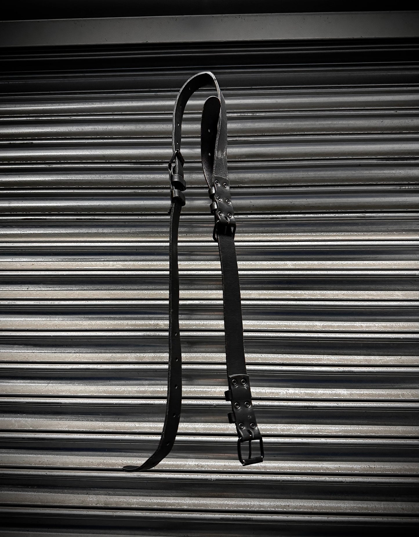 Black leather strap on a corrugated metal background