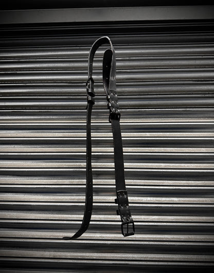 Black leather strap on a corrugated metal background