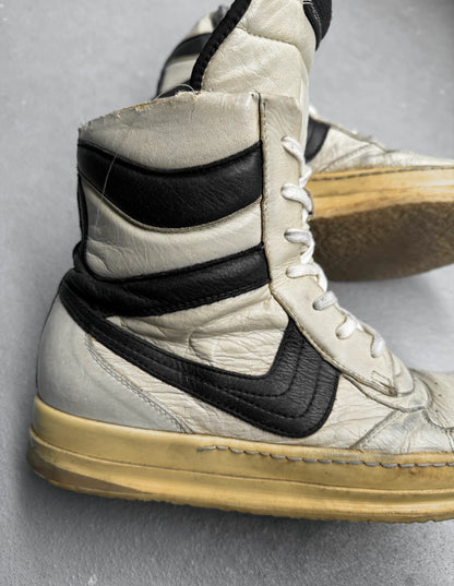 White high-top sneakers with black swoosh logo on a gray background