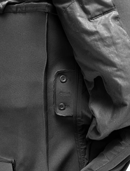 Close-up of a dark coat with buttons and a hood.