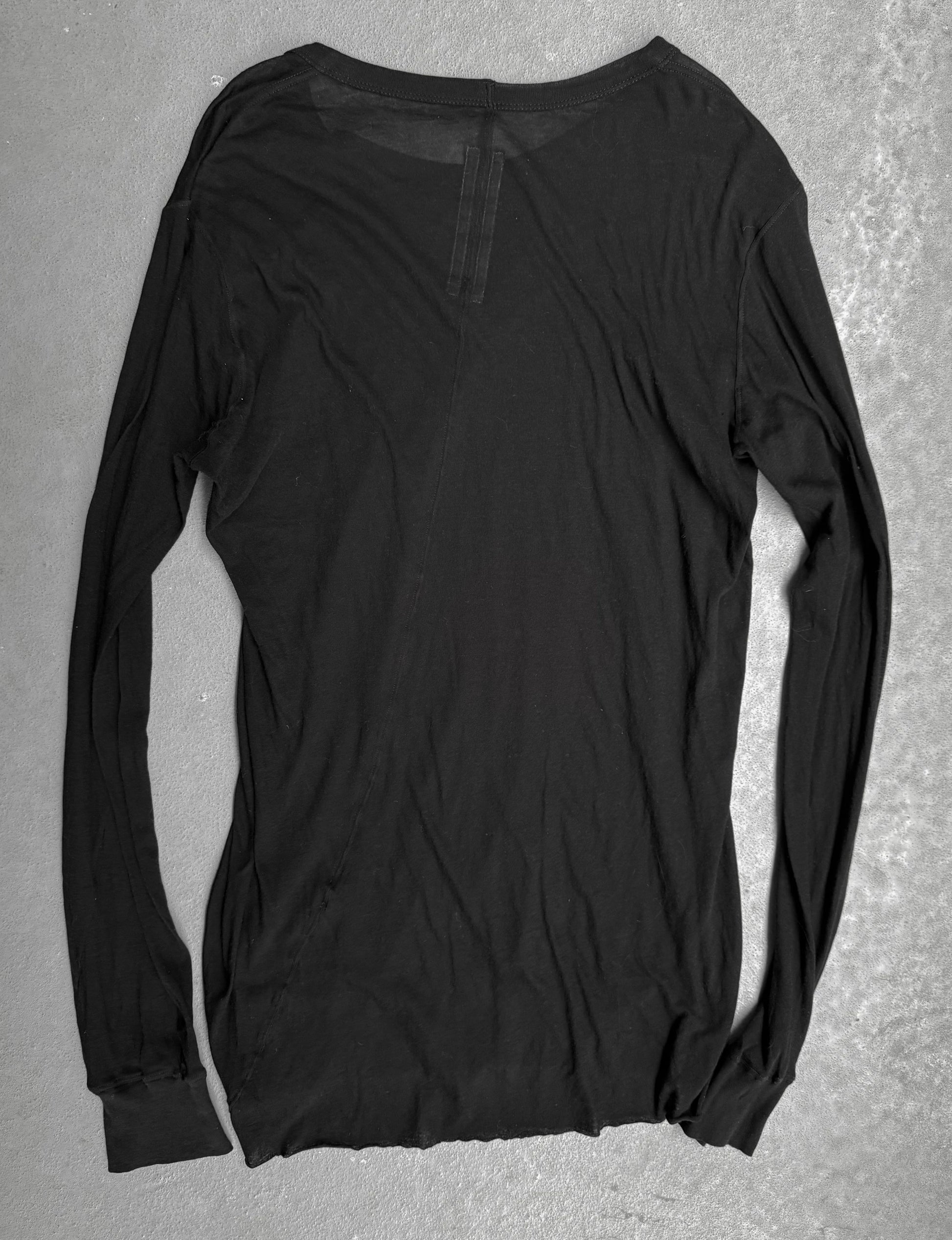 Black long-sleeve shirt on a gray surface