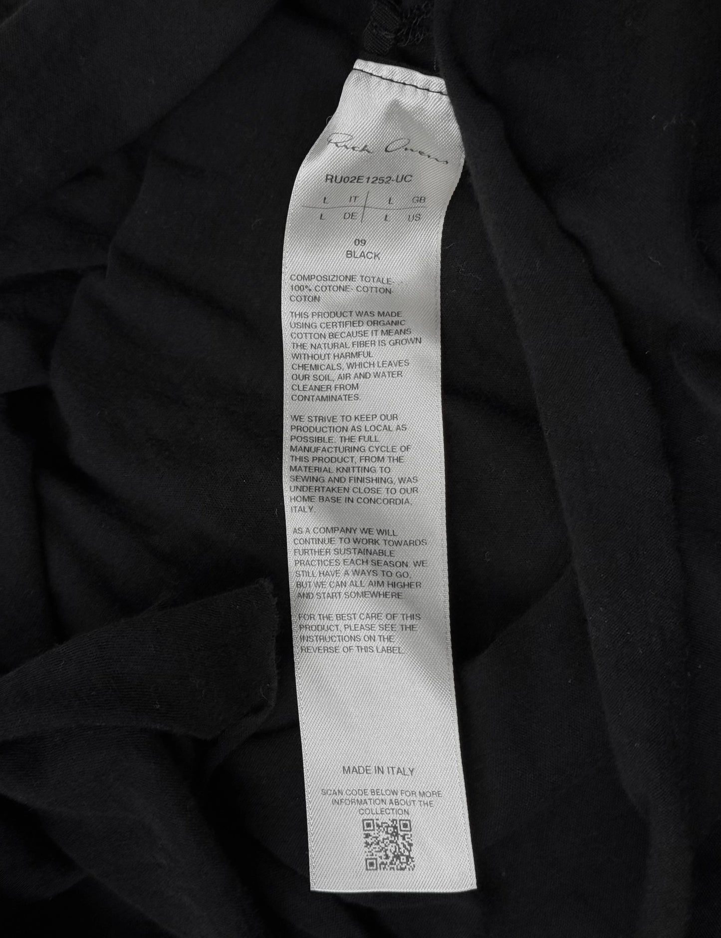 Black fabric with a label detailing material composition and production details.