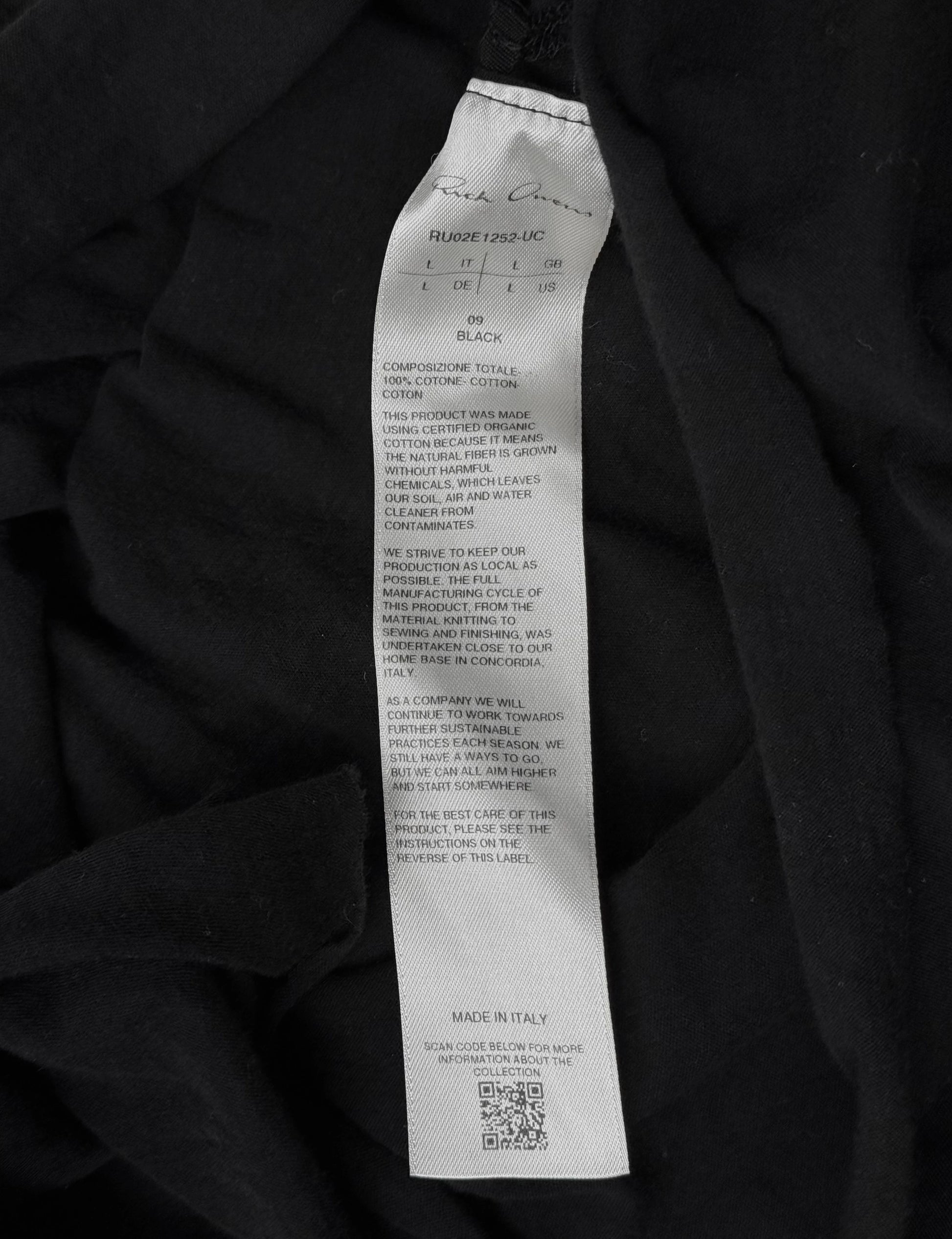 Black fabric with a label detailing material composition and production details.