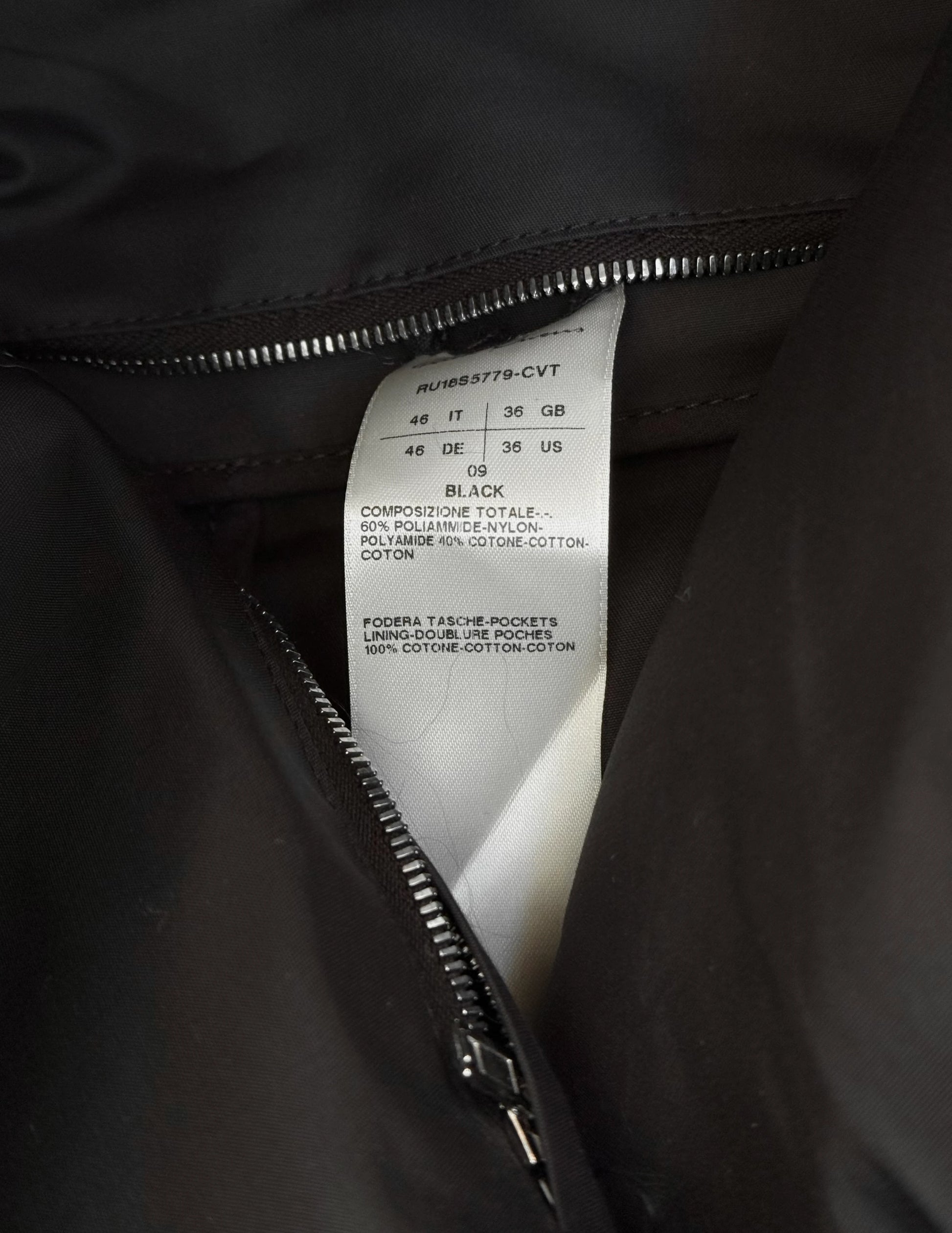 Close-up of a black jacket with a label showing size and material details.
