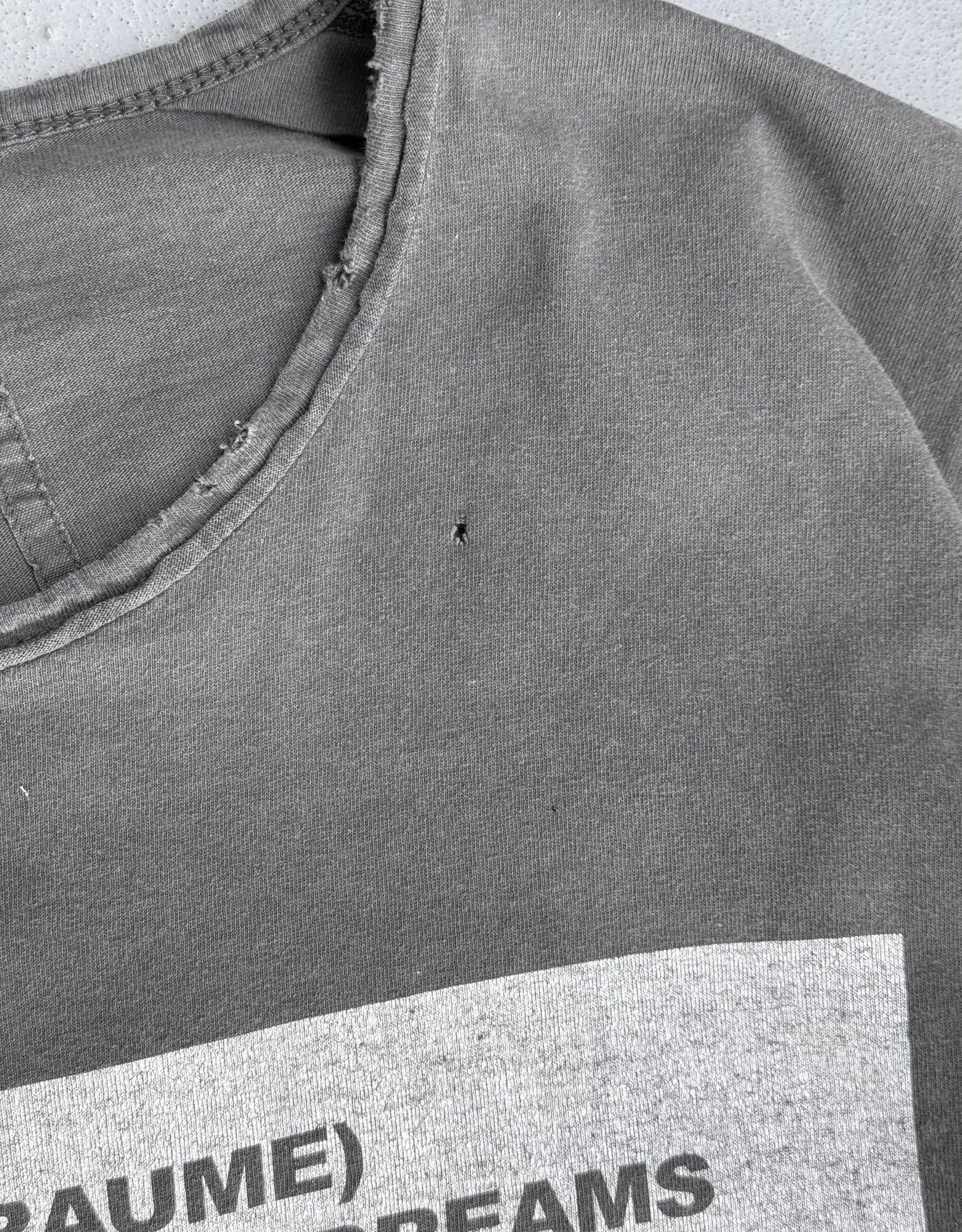 Gray t-shirt with text on a plain background