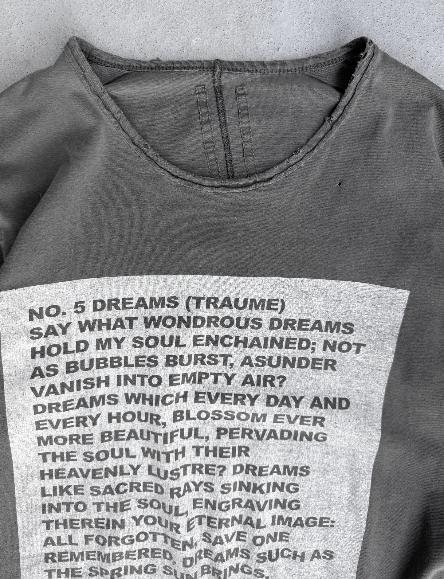 Gray sweatshirt with printed text on a textured surface