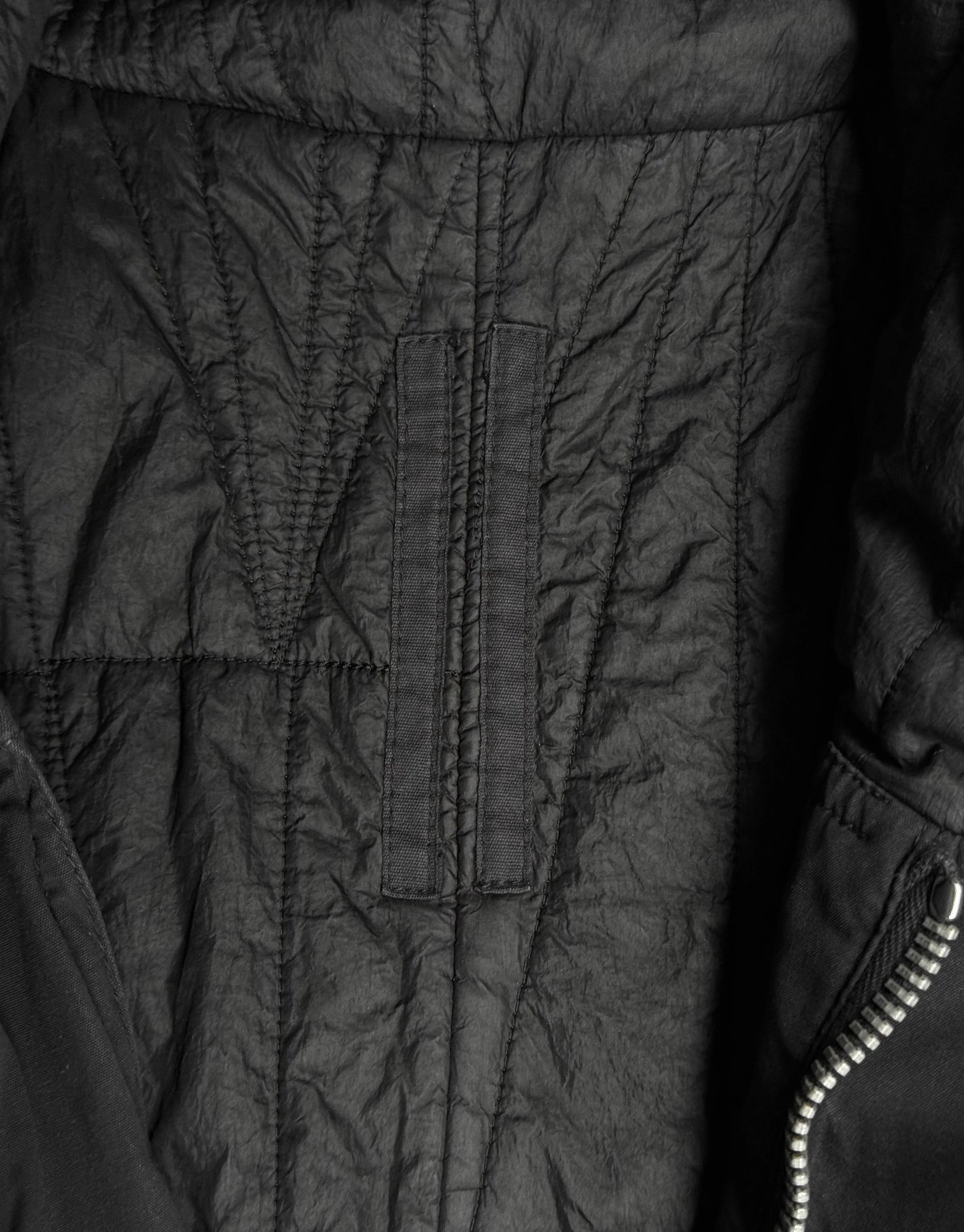 Close-up of a black quilted jacket with visible stitching details.