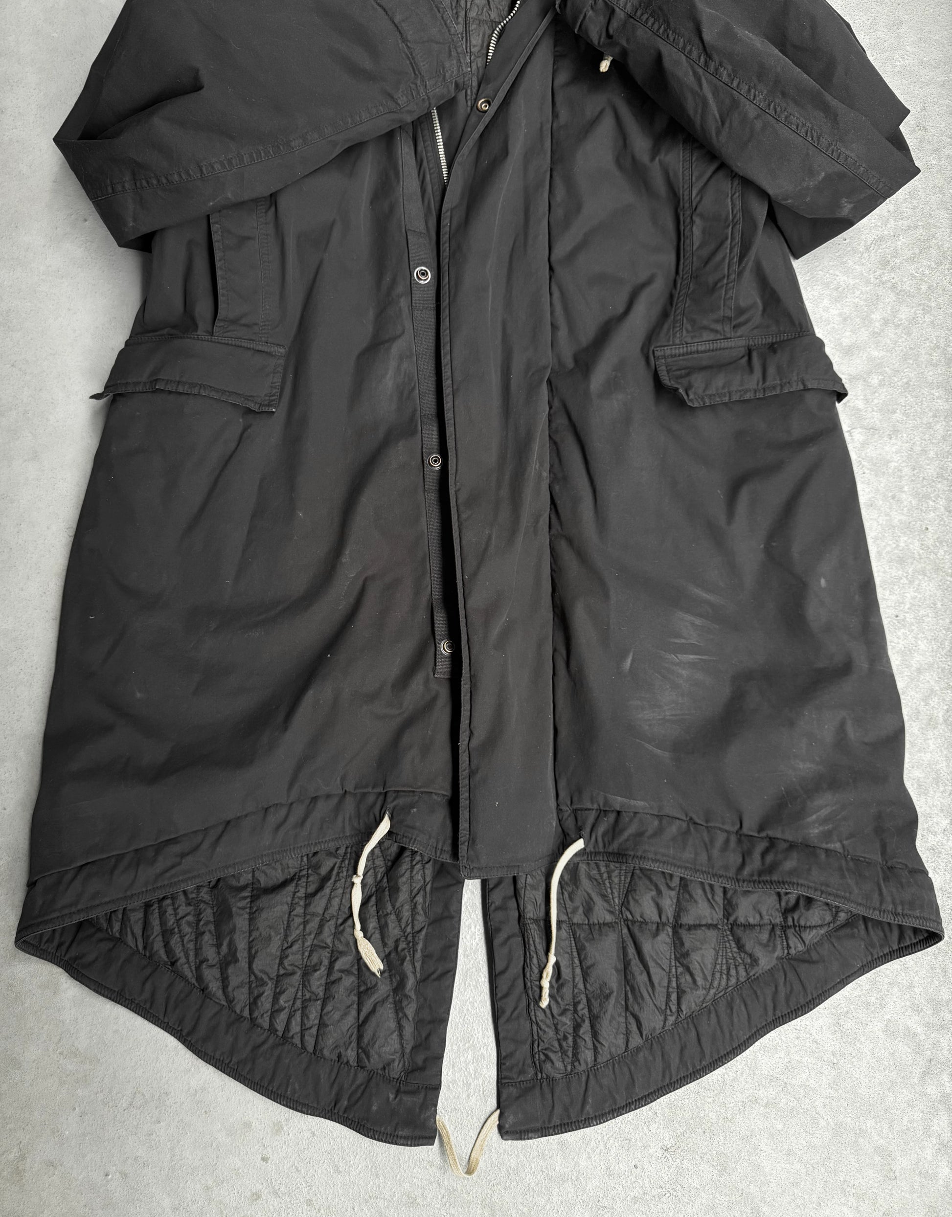 Black jacket with quilted design on a light gray background