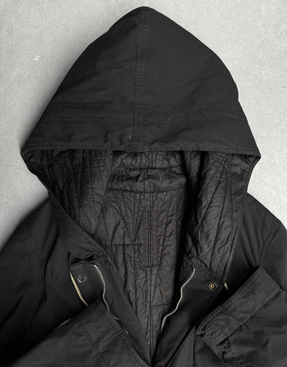 Close-up of a black hooded jacket against a gray background