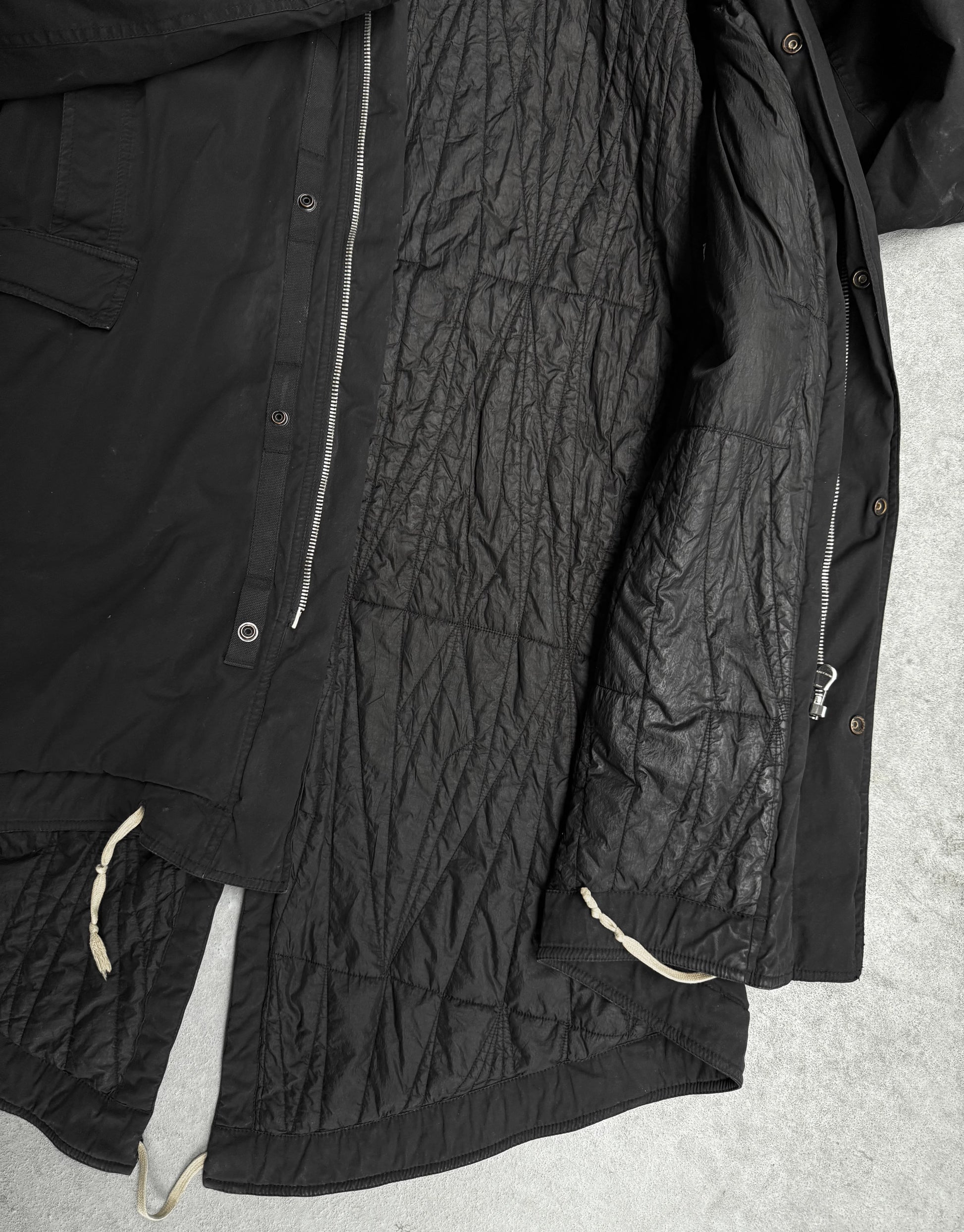 Black quilted jacket on a light gray background