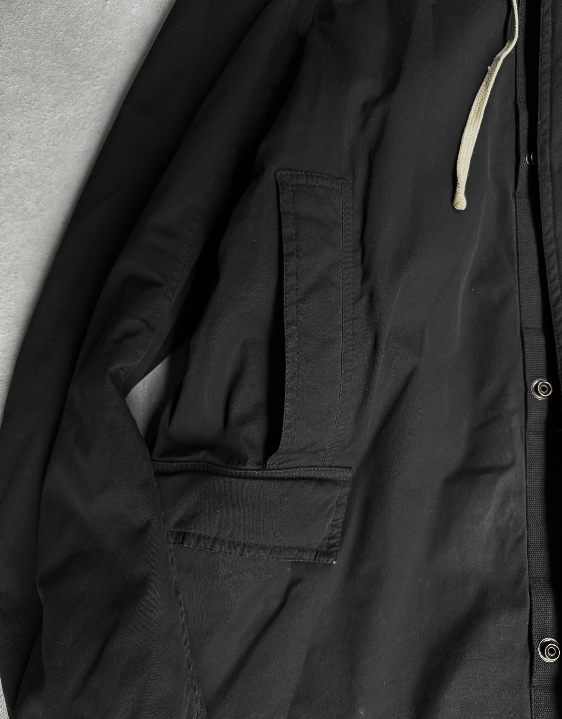 Close-up of a black jacket with a pocket and zipper detail.