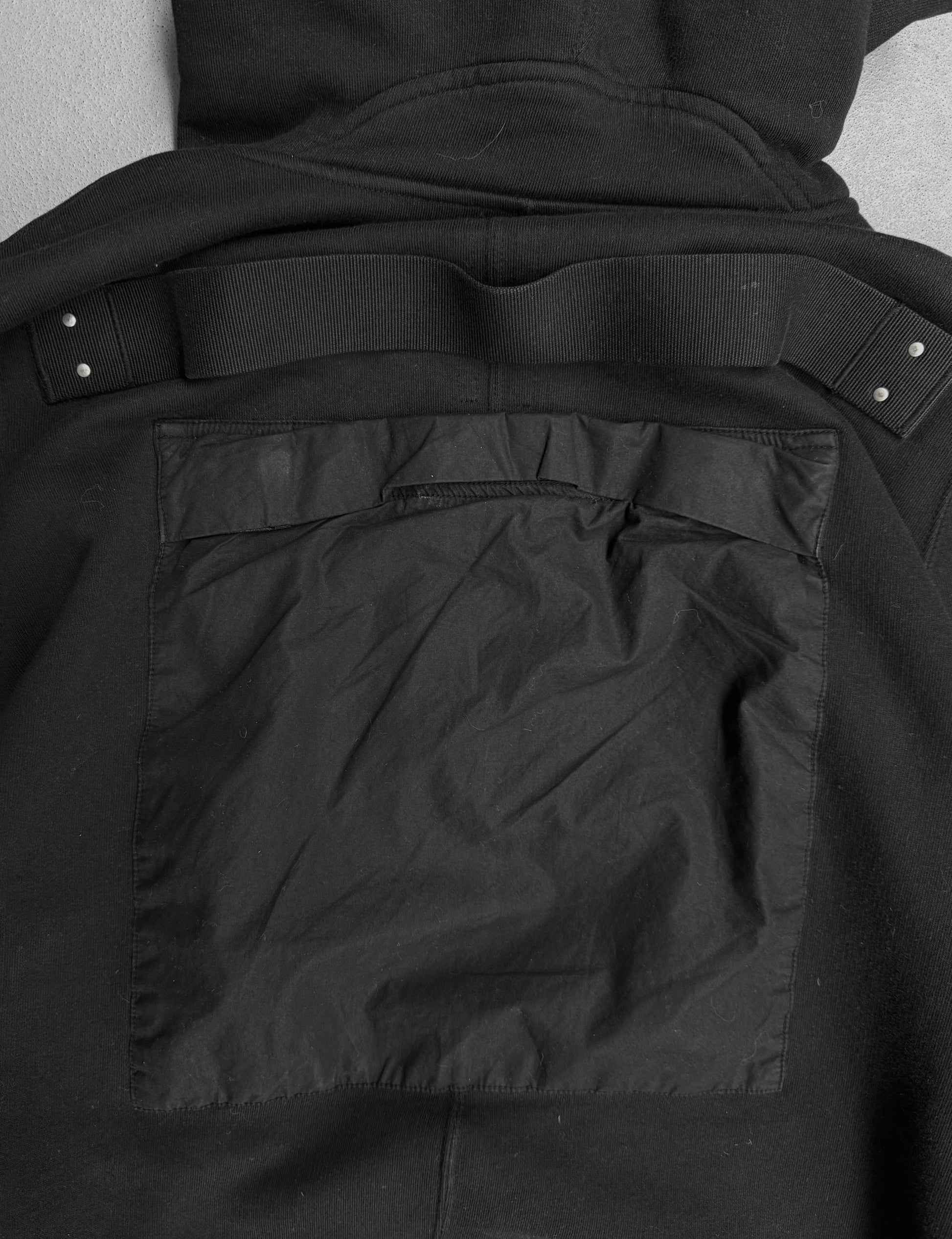 Close-up of a black jacket with a pocket detail on a gray background