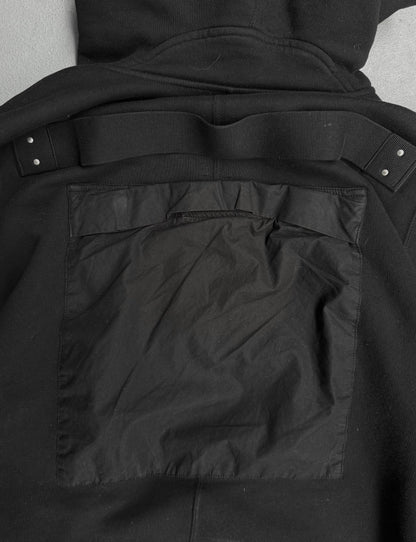 Close-up of a black jacket with a pocket detail on a gray background