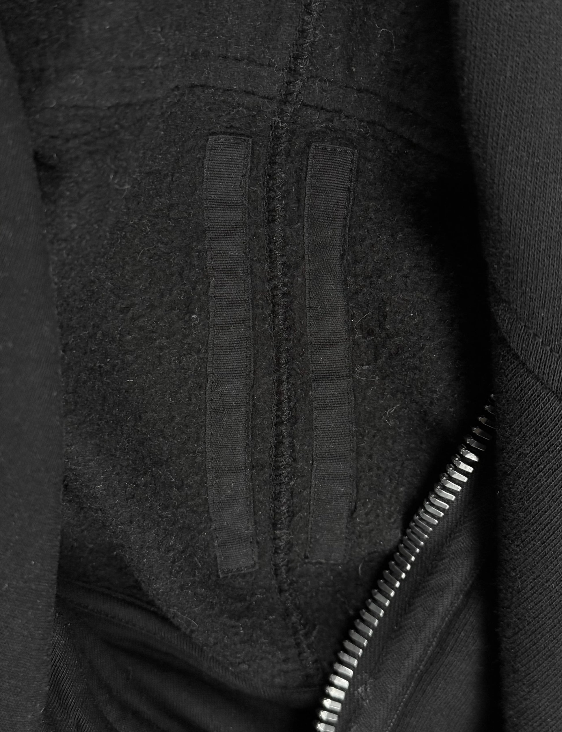 Close-up of a textured black fabric surface with a zipper