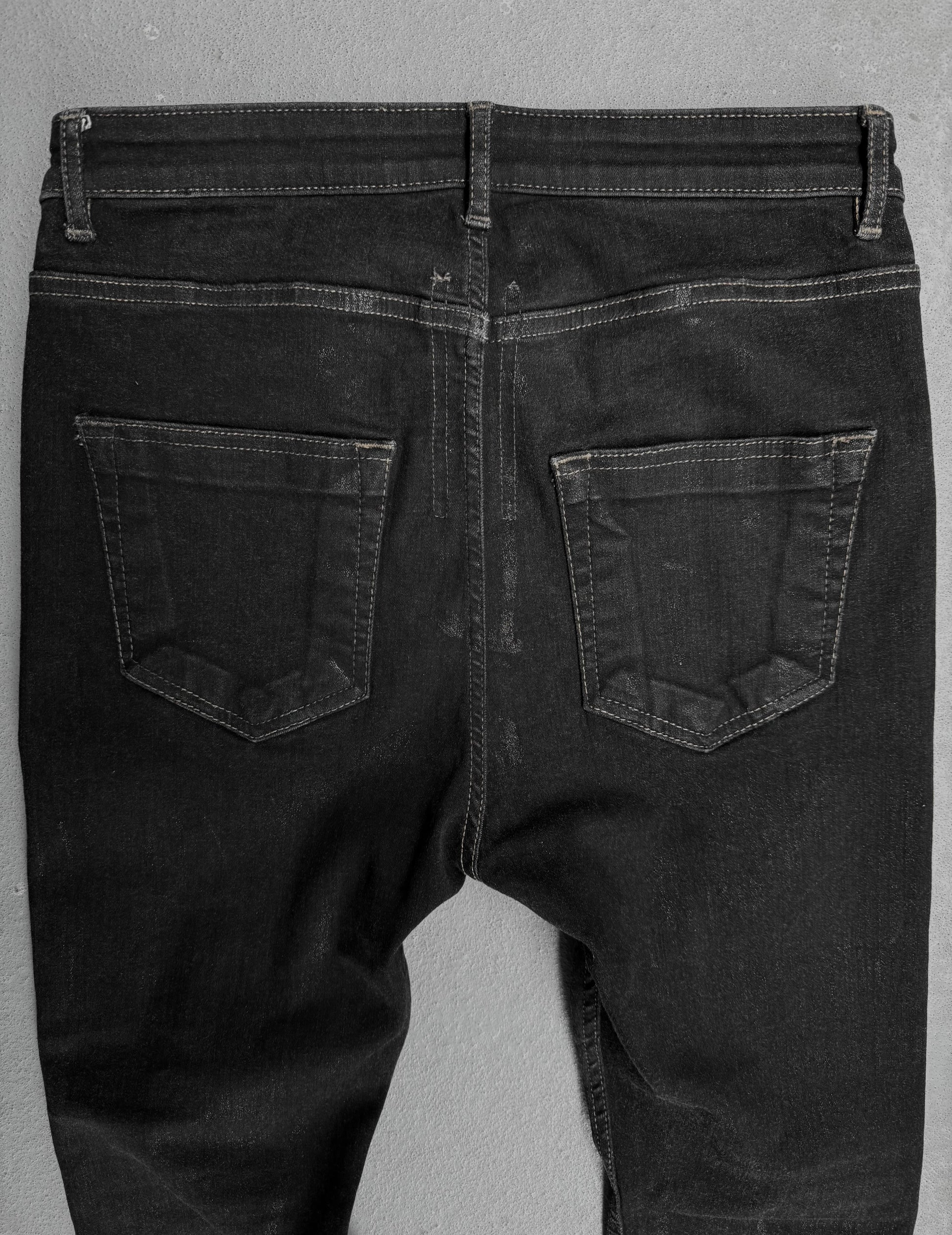 Black jeans shown from the back on a gray background