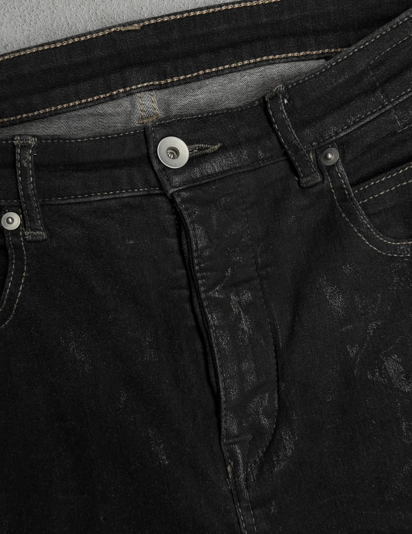 Close-up of black denim jeans with stitching details