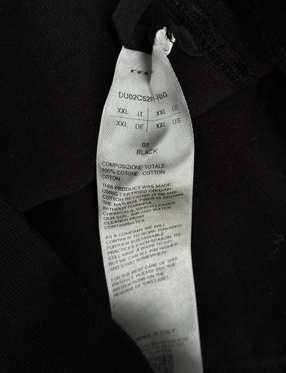Close-up of a black tie with visible label details on a dark background