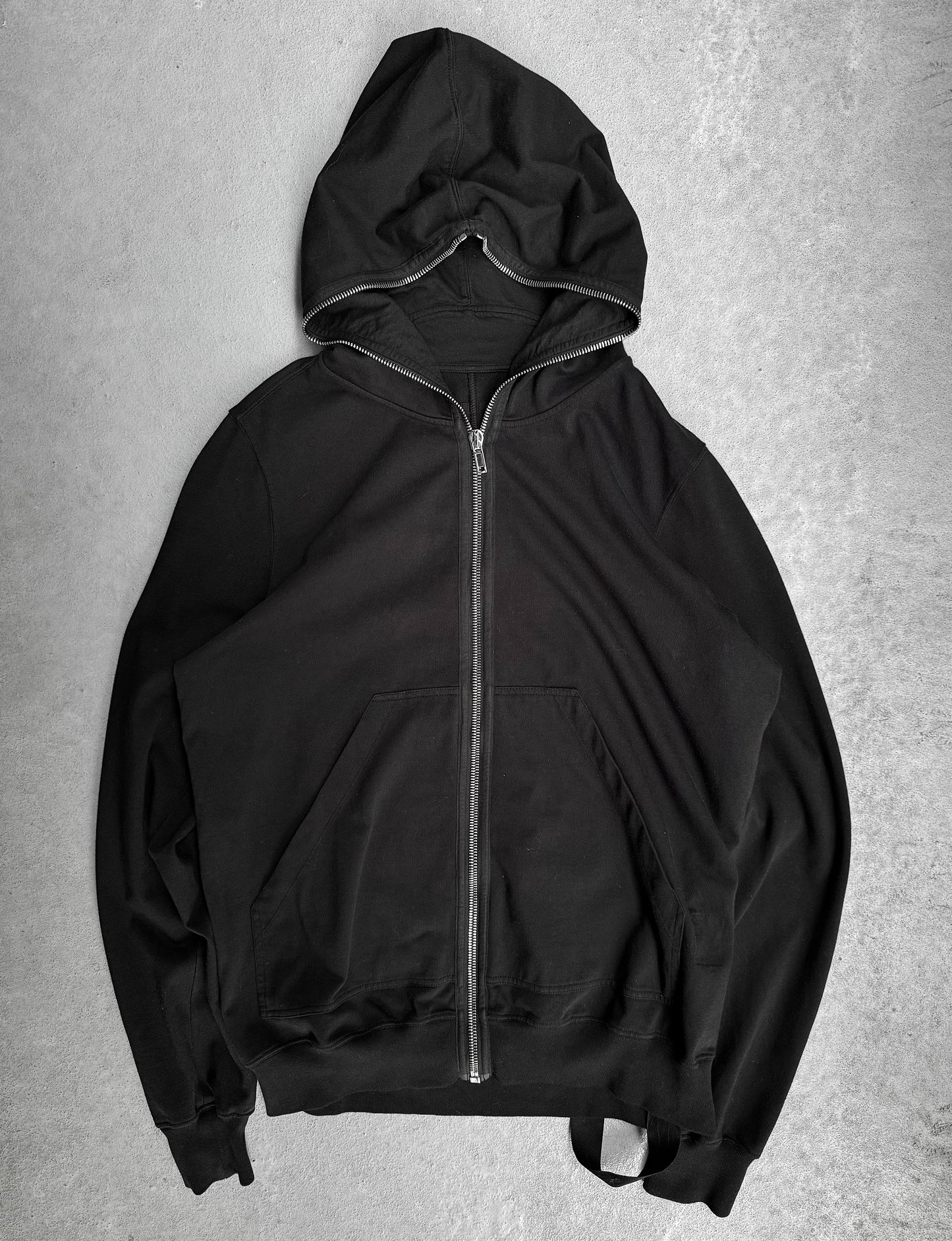 Black hoodie with a zipper on a gray background