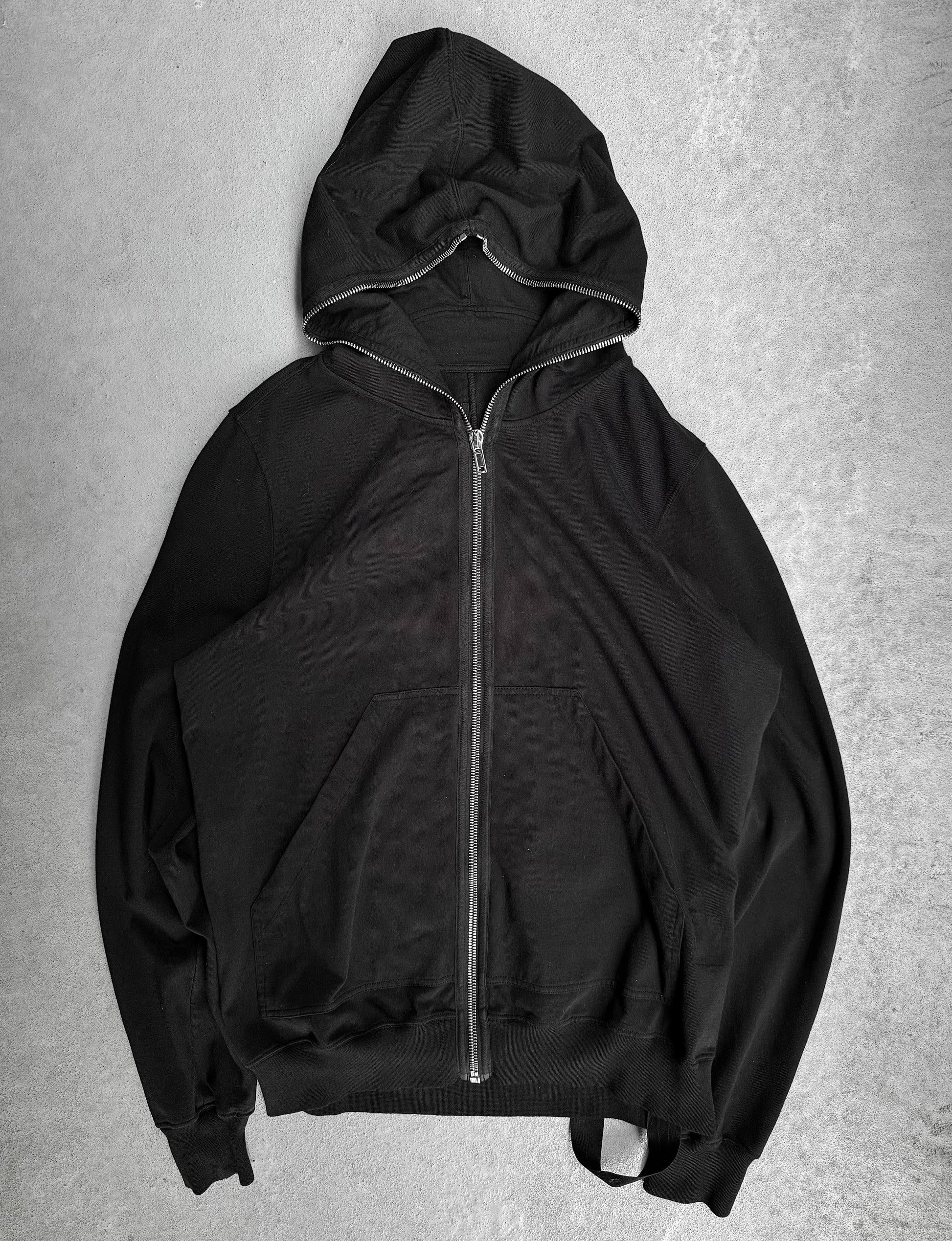 Black hoodie with a zipper on a gray background
