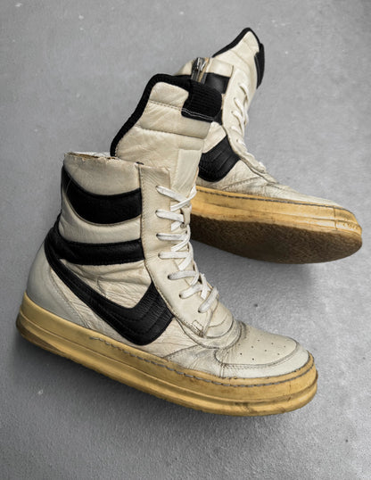 Pair of high-top sneakers with black accents on a gray background