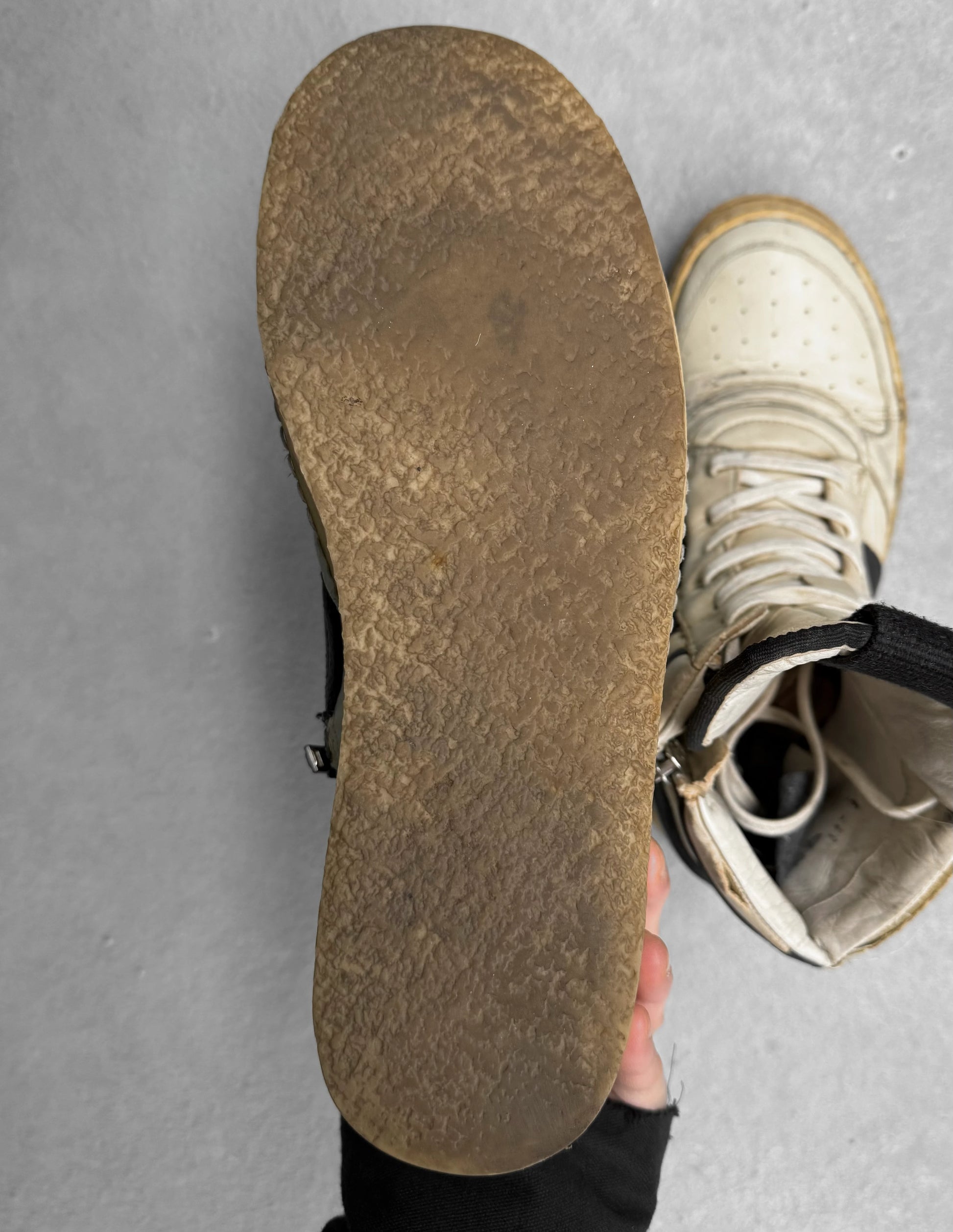 Close-up of a worn-out shoe sole on a gray surface