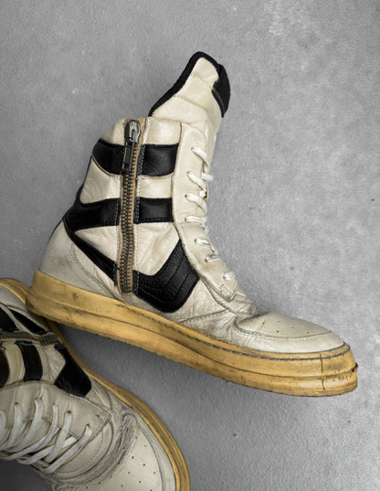 Pair of high-top sneakers with a zipper detail on a gray background