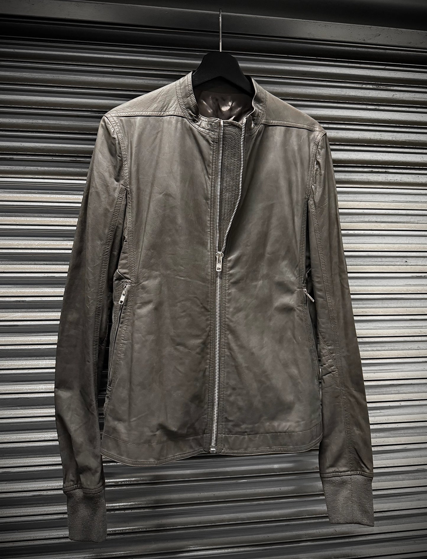 Brown jacket hanging against a metallic shutter background
