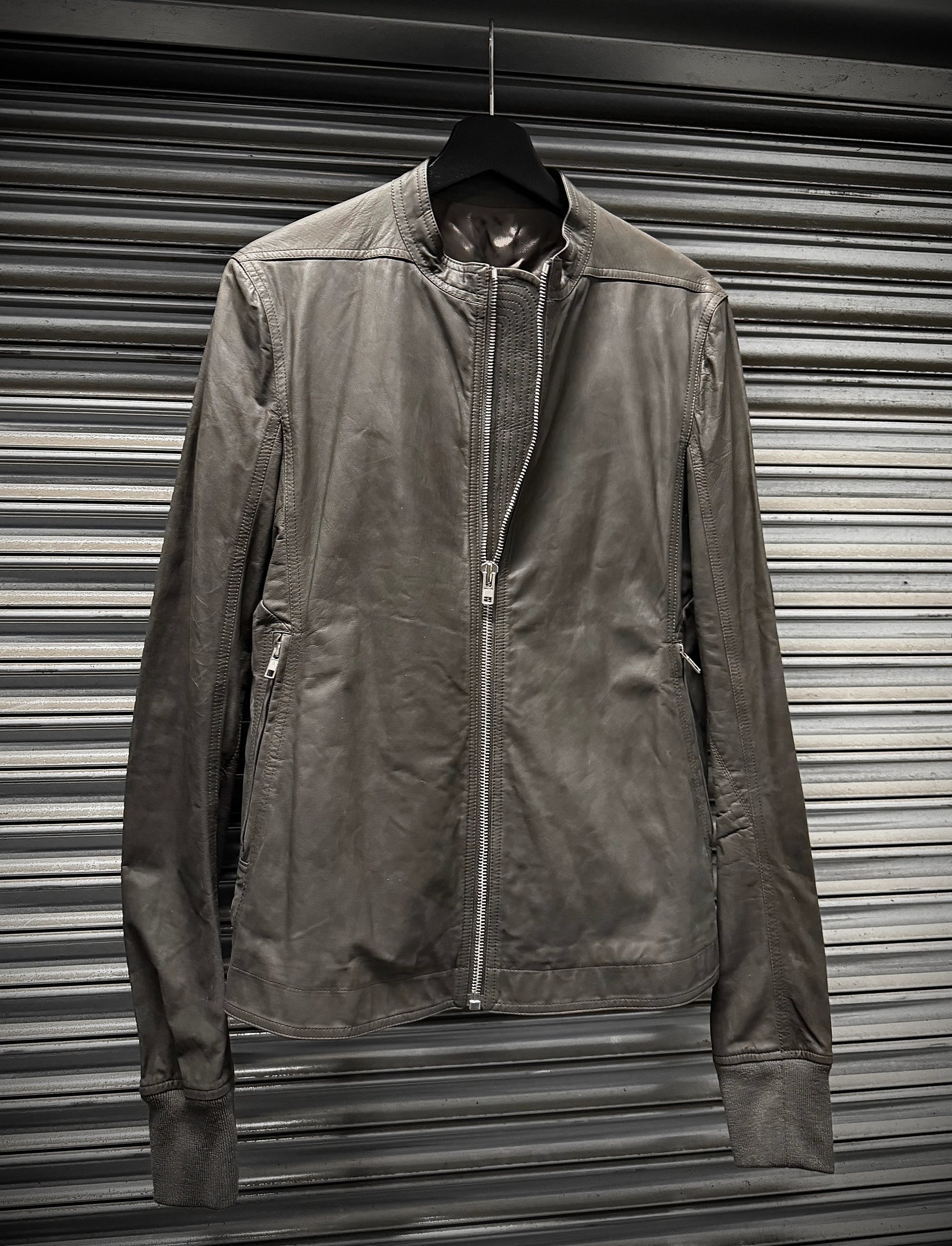 Brown jacket hanging against a metallic shutter background