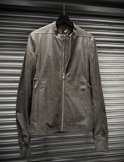 Brown jacket hanging against a metallic shutter background