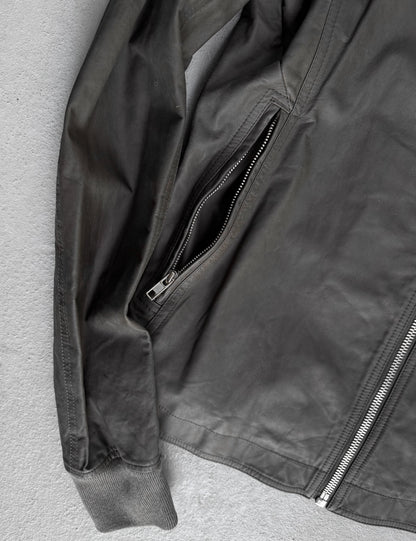 Close-up of a dark gray jacket with zippers on a light gray background