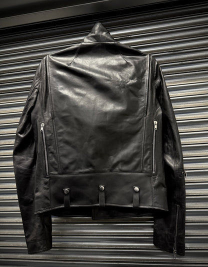 Black leather jacket hanging against a metallic background