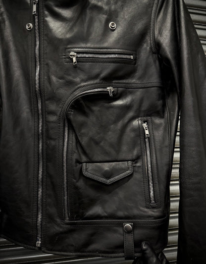 Close-up of a black leather jacket with zippers on a metallic surface