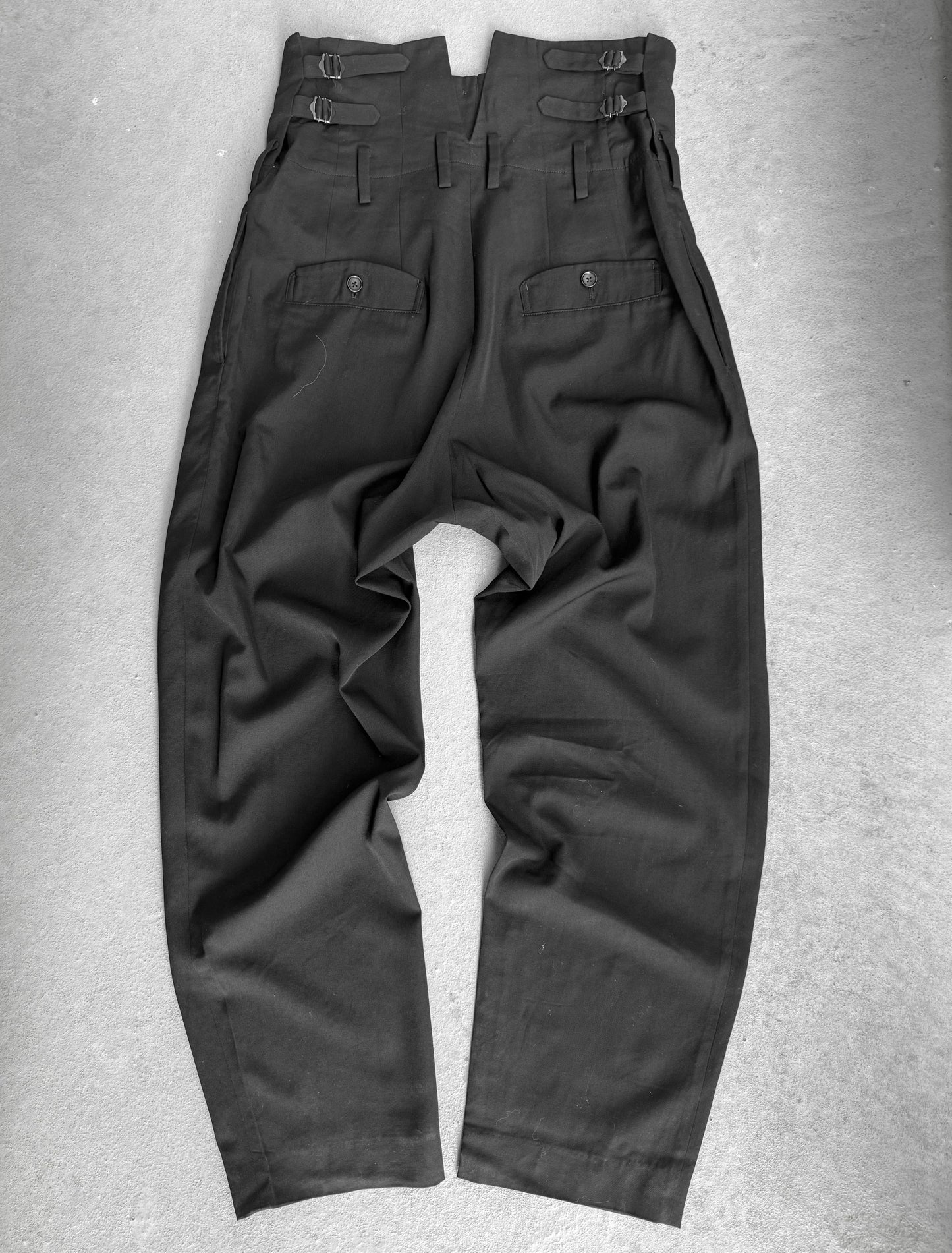 Dark gray pants on a textured gray surface