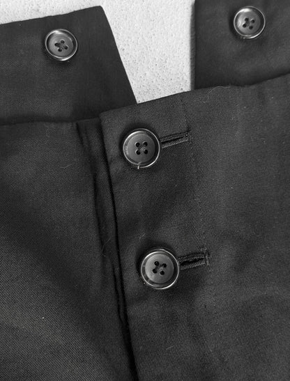 Close-up of a black coat with buttons on a textured surface