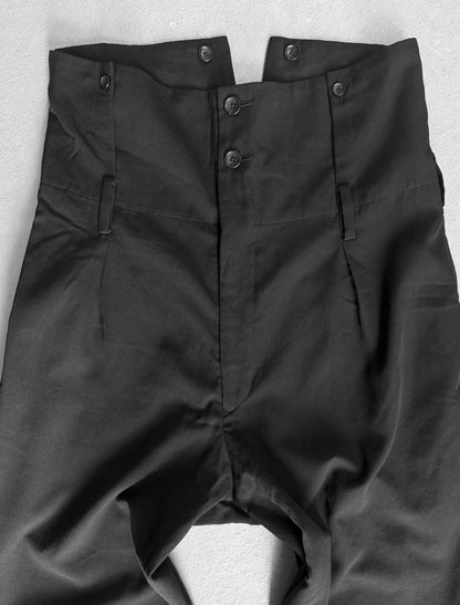 Black pants with buttons on a light gray background