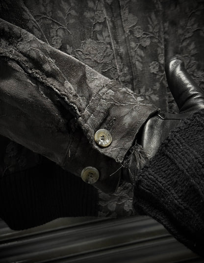 Close-up of a textured fabric surface with buttons and leather elements.