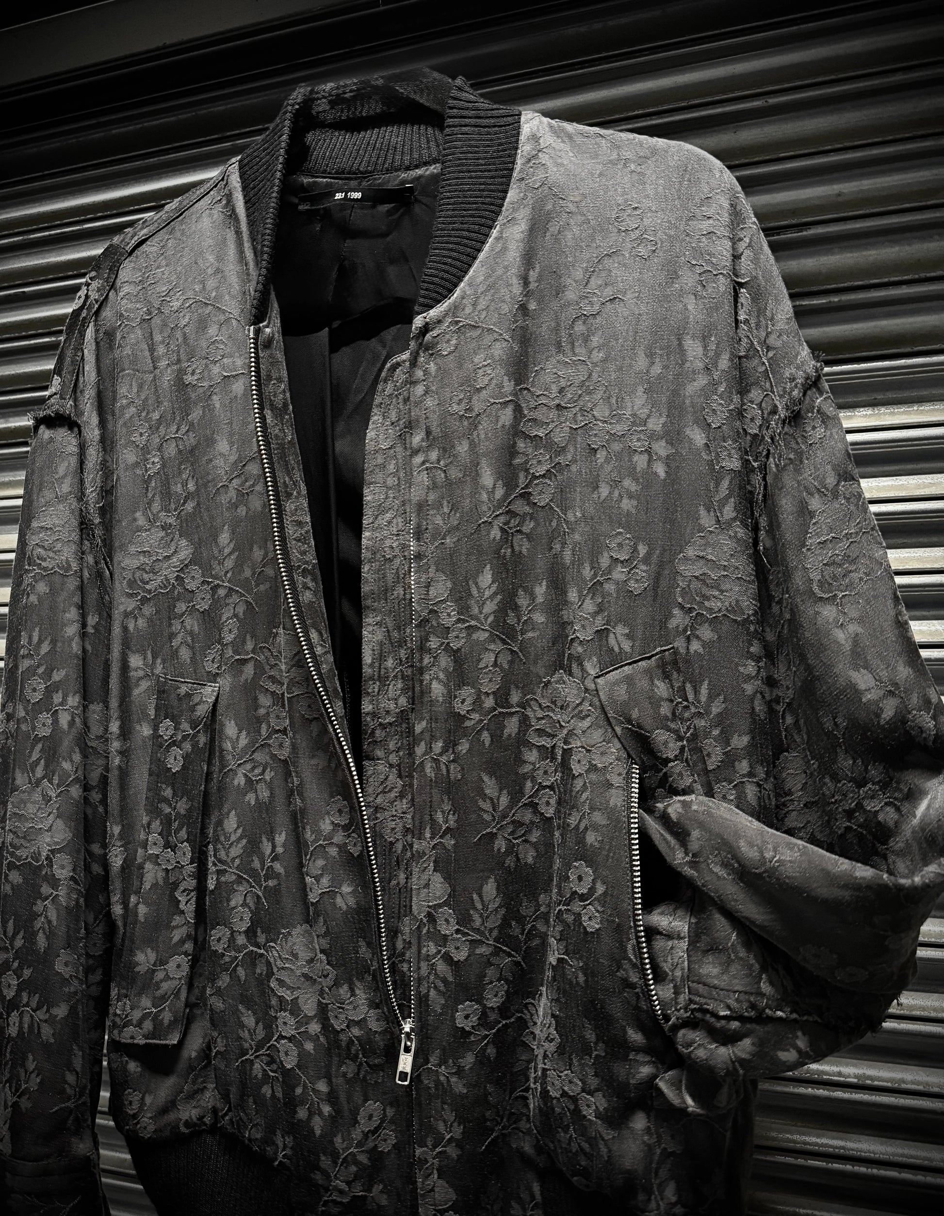 Floral patterned jacket on a mannequin against a corrugated metal background