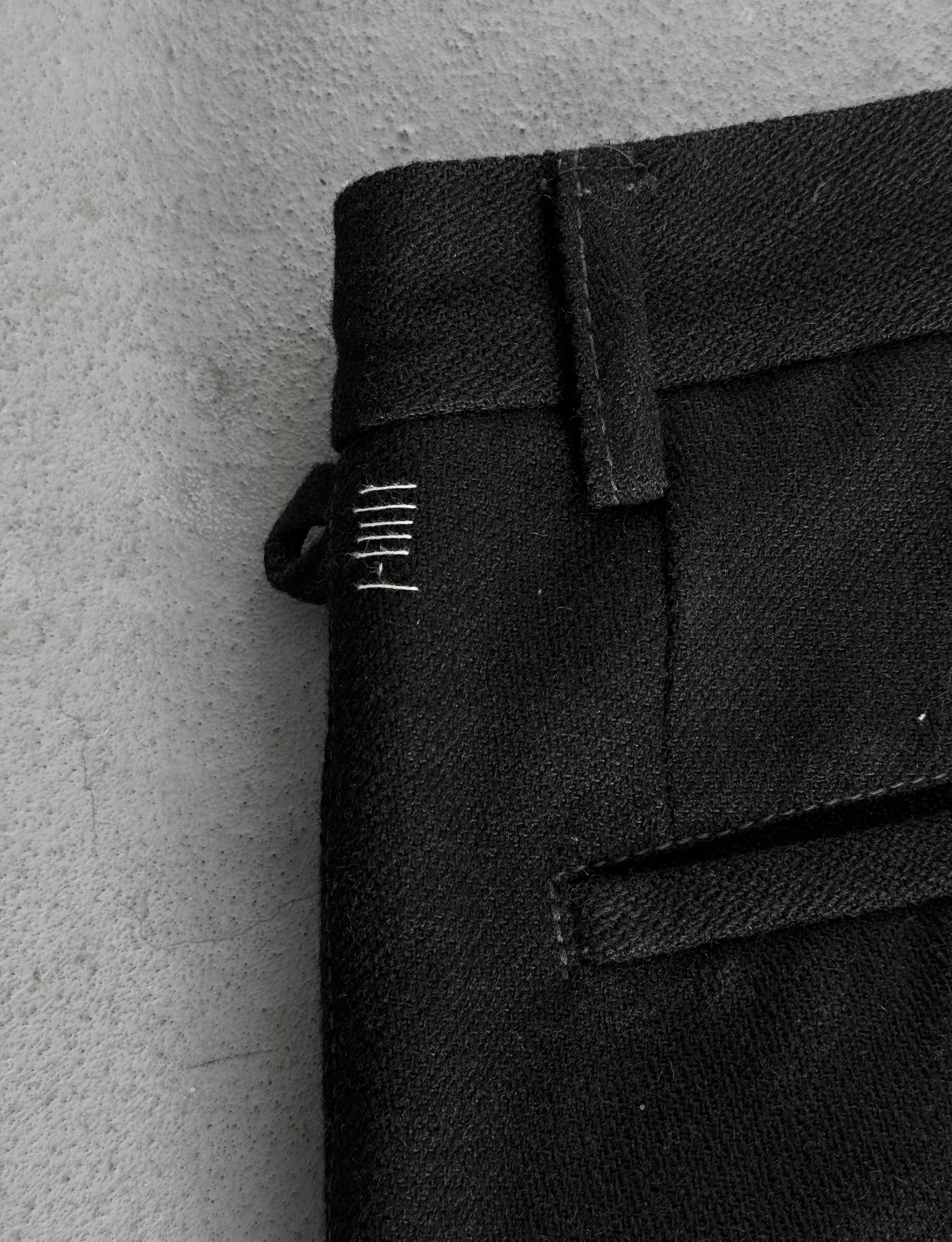 Close-up of a black fabric with a brand label on a gray background