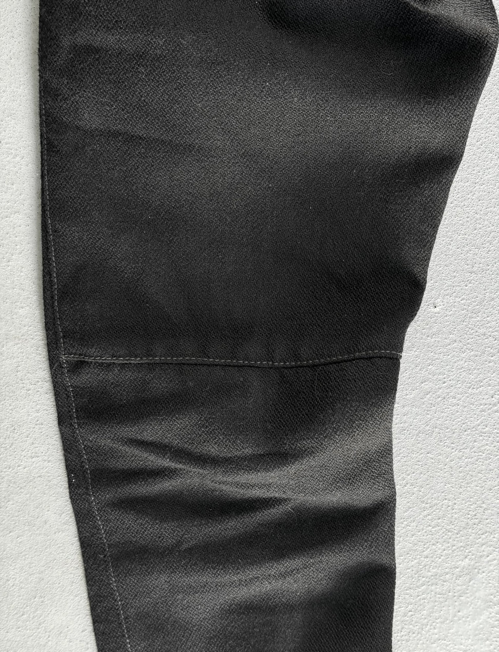 Close-up of black pants on a light gray background