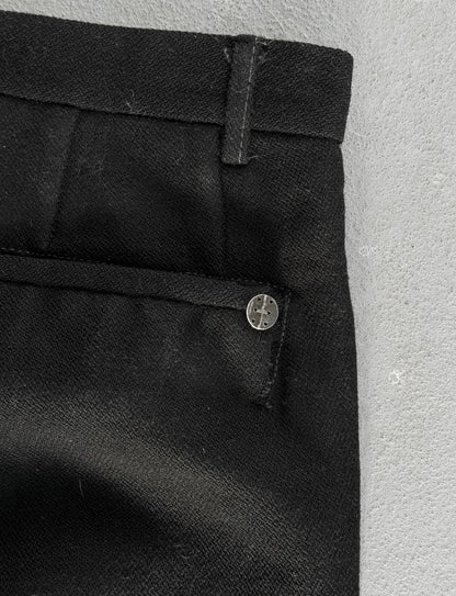 Close-up of black pants with a button on a light gray background