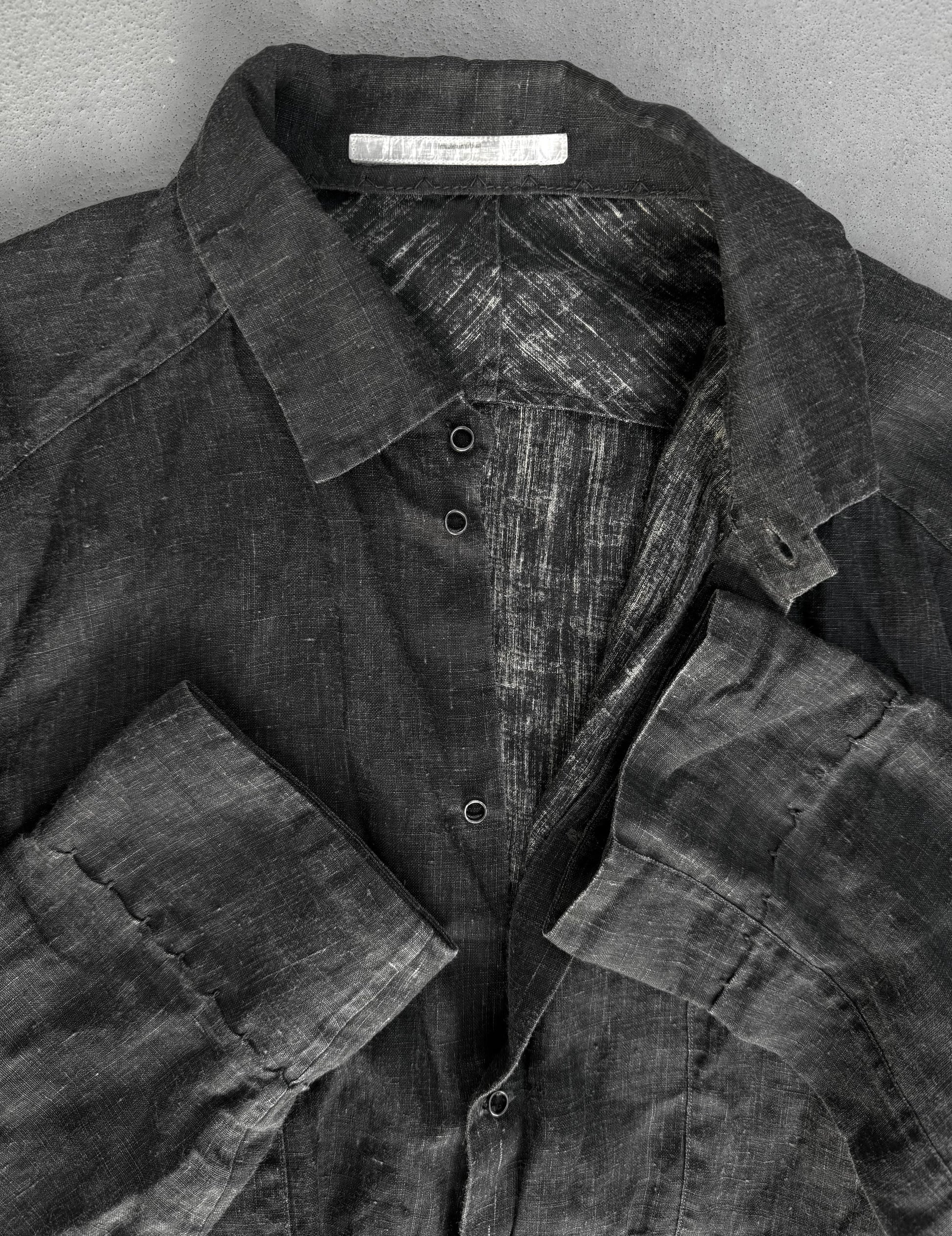 Dark denim shirt with a visible brand label on a gray background
